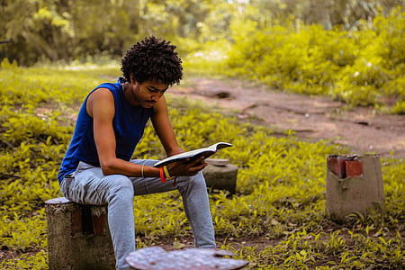 man reading book sitting on outdoors thumbnail