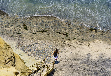 woman running towards body of water thumbnail