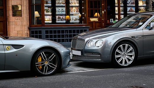 gray Bentley Continental sedan parked on sidewalk infront of gray Ferrari sports coupe thumbnail