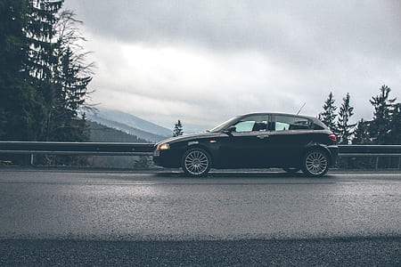 black 5-door hatchback parked on road thumbnail