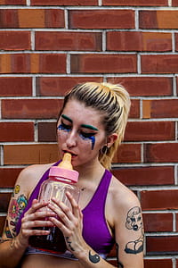 Woman Placing Feeding Bottle on Her Lips thumbnail