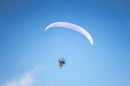 person paragliding under blue sky thumbnail