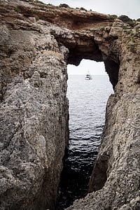 boat moving toward rock thumbnail