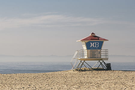 white lifeguard outpost near body of water during daytime thumbnail