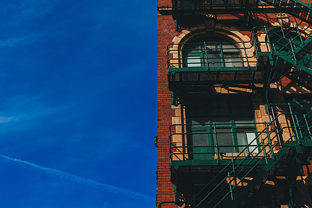 low angle photo of red brick building with fire exit stairway thumbnail