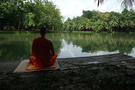 monk near body of water during daytime thumbnail