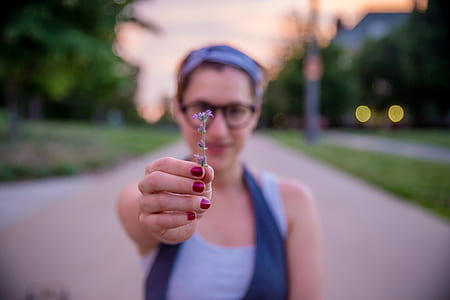 depth of field photography of woman holding purple flower thumbnail