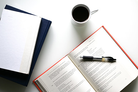 Overhead shot of coffee, books and pen thumbnail