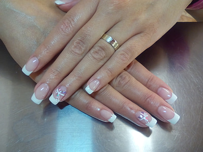 woman wearing gold-colored ring and white French-tip manicures thumbnail