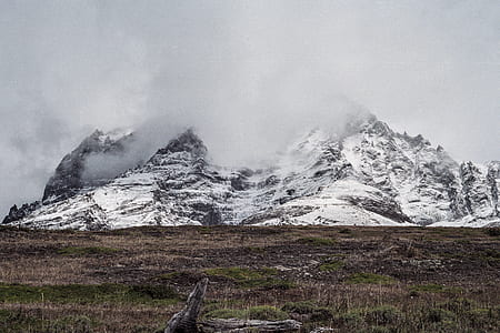 mountain covered by snow under white cloudy sky thumbnail