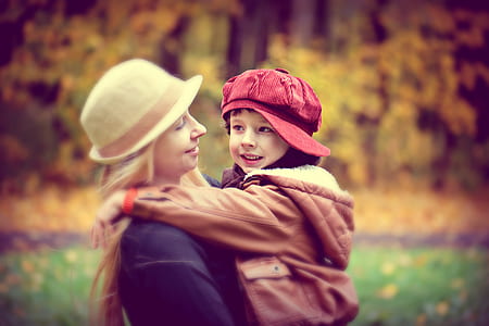 selective focus photography of woman and boy standing on grass thumbnail