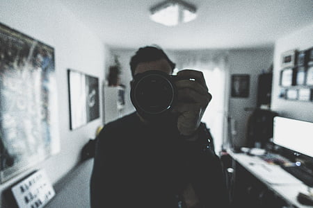man holding camera inside room thumbnail