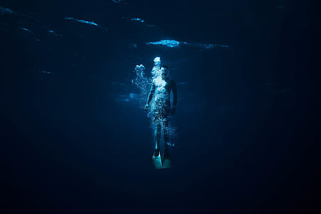 man diving in sea while taking picture thumbnail