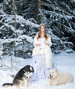 woman wearing white dress and coat standing near two wolves thumbnail