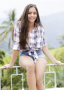 woman wearing white and purple plaid shirt and blue denim short shorts thumbnail