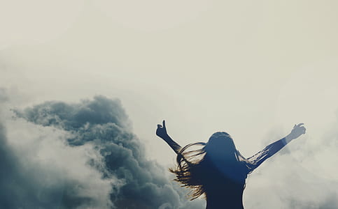 woman raising hands surrounded by clouds thumbnail