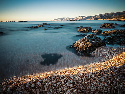 close-up photo of bodies of water near mountain at daytime thumbnail