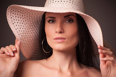 woman holding her brown sun hat in portrait photography thumbnail