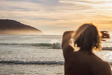 selective focus photography of short-haired person looking on sea waves thumbnail