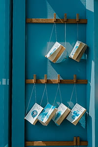 white-and-blue title book hanging on brown wooden rack thumbnail