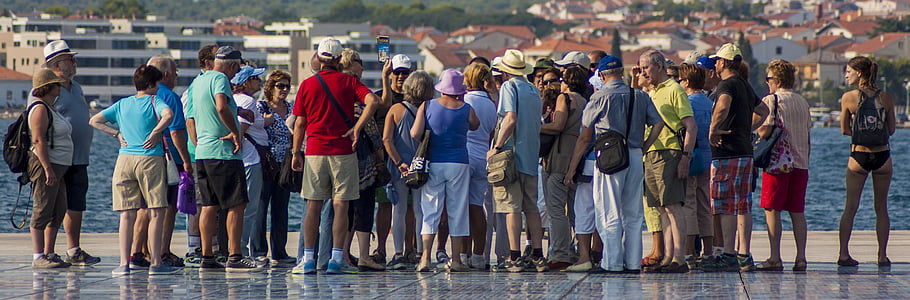 crowd of people standing near body of water thumbnail
