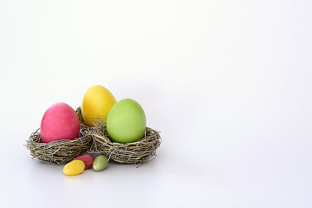 pink, yellow, and green Easter egg on brown nest thumbnail