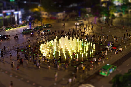 tilt-shift photography of people walking near fountain thumbnail