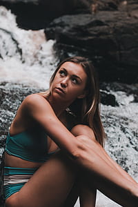 woman sitting near body of water thumbnail