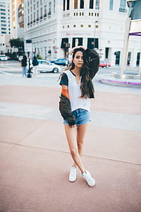 woman standing on brown concrete floor in city during daytime thumbnail