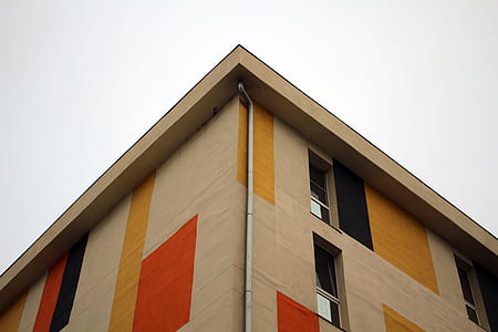 low-angle beige concrete building under white sky during daytime thumbnail