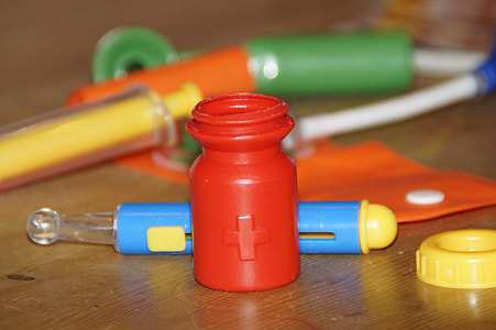 red plastic bottle on brown wooden surface thumbnail