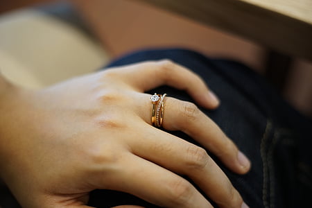 person wears gold-colored wedding band thumbnail