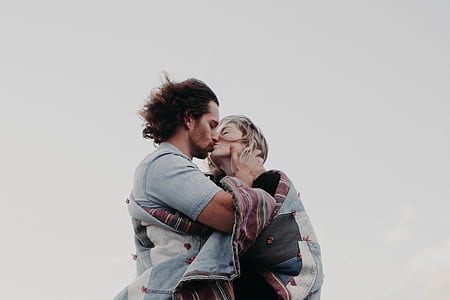 man and woman kissing under blue sky during daytime thumbnail