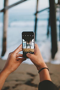 person taking photo under wooden dock at daytime thumbnail