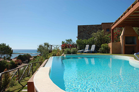 two blue loungers beside pool during daytime thumbnail