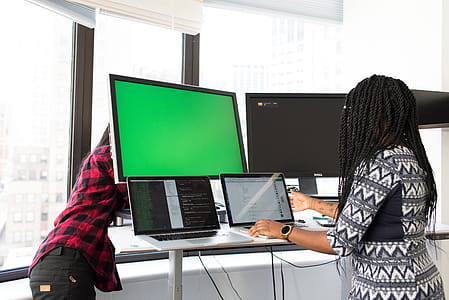 Woman Wearing White, Gray, and Black Elbow-sleeved Dress Using Macbook Pro thumbnail