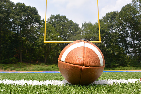 brown American football on green grass thumbnail
