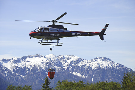 blue chopper flying over the trees thumbnail