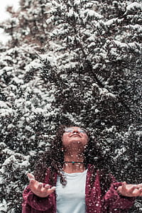girl standing under tree covered with snow thumbnail