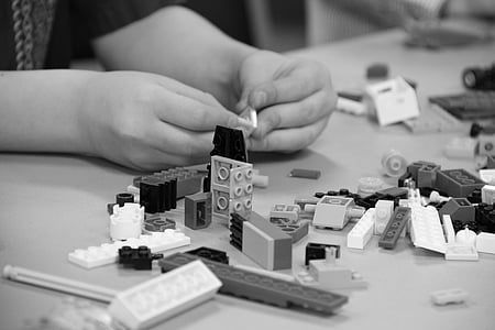 grayscale photo of person playing Lego pieces thumbnail