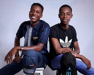 Two Men Taking Photo in Front of White Wall thumbnail