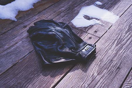 pair of black leather gloves on wooden surface thumbnail