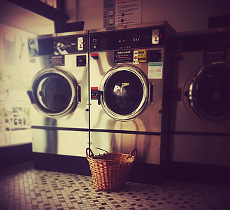 two closed gray front-load clothes washing machines beside basket thumbnail
