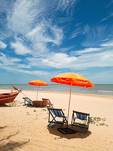 beach umbrella and chair near body of water at daytime thumbnail