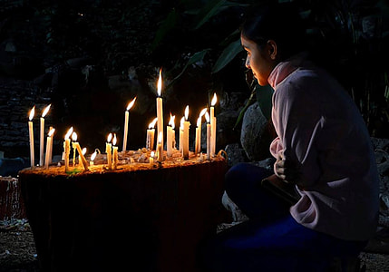 woman sitting near brown surface with candle lighted thumbnail