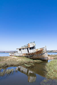wrecked brown boat on shore thumbnail