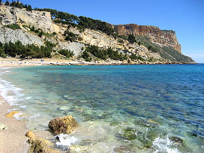 seashore near cliff under blue sky during daytime thumbnail