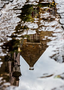 reflection of house on body of water during daytime thumbnail