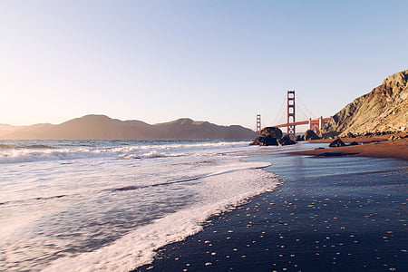 bridge near sea and mountain at daytime thumbnail