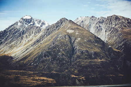 brown rocky mountain with icy caps during day thumbnail